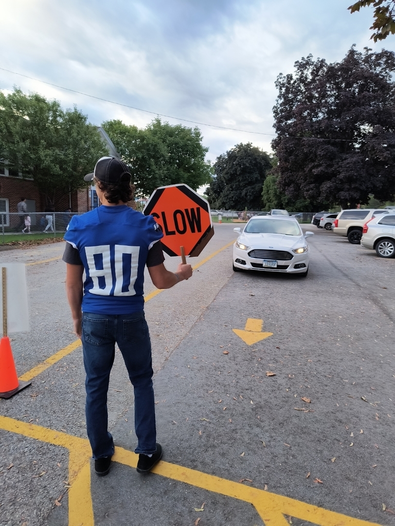 football player holding stop sign in crosswalk